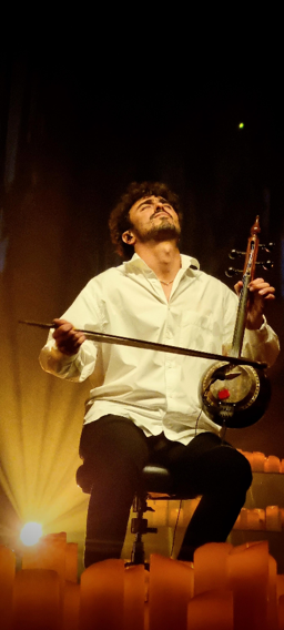 צילום של מארק אליהו אוחז בכלי נגינה 